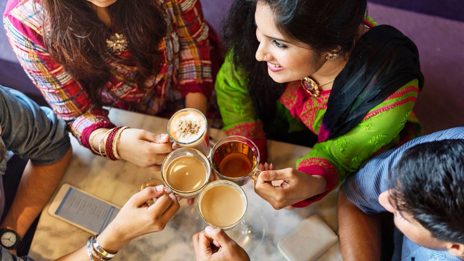 Friends sharing cups of chai around a table