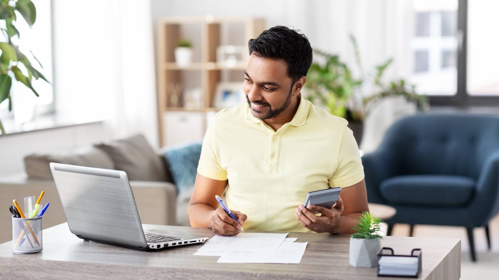 Man working out costs with a calculator and papers